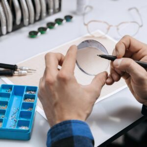 Closeup of man's hands marking lens for eyeglasses